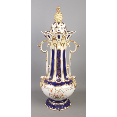 180 - A large ceramic lidded, twin handle jar decorated with floral motifs and topped with pineapple finia... 