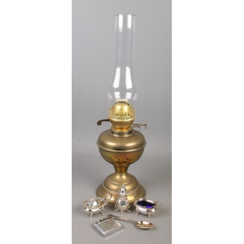 192 - A brass oil lamp along with a collection of white metal items. Includes Mosda Streamline 500 lighter... 