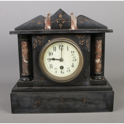 219 - A slate and marble mantle clock featuring column decoration.