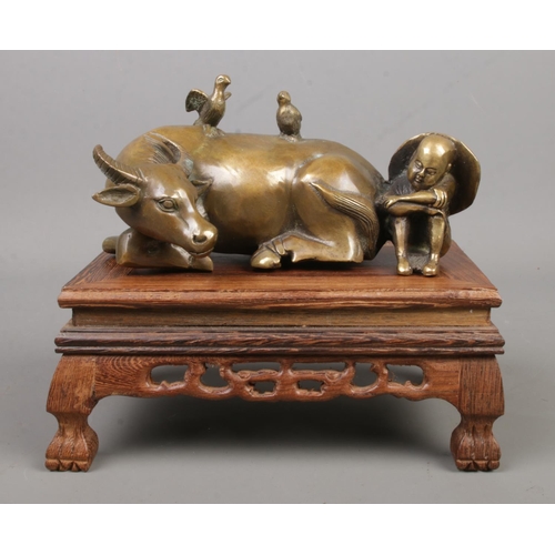 233 - A Chinese bronze sculpture formed as a seated man next to a recumbent water buffalo. Bearing charact... 