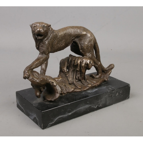 235 - A bronze sculpture of a cheetah raised on marble base. Height 15.5cm, Length 19cm.