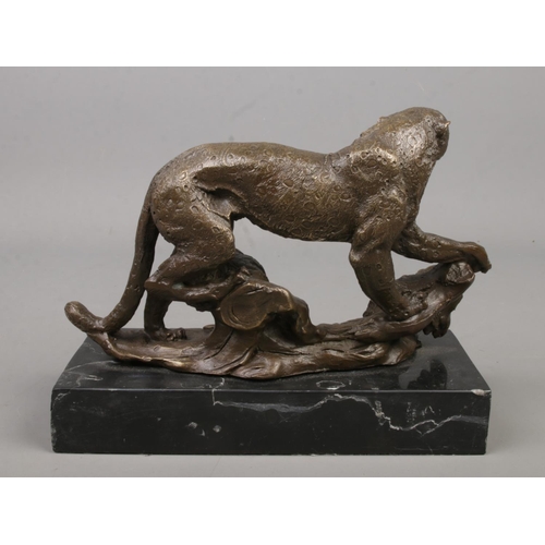 235 - A bronze sculpture of a cheetah raised on marble base. Height 15.5cm, Length 19cm.