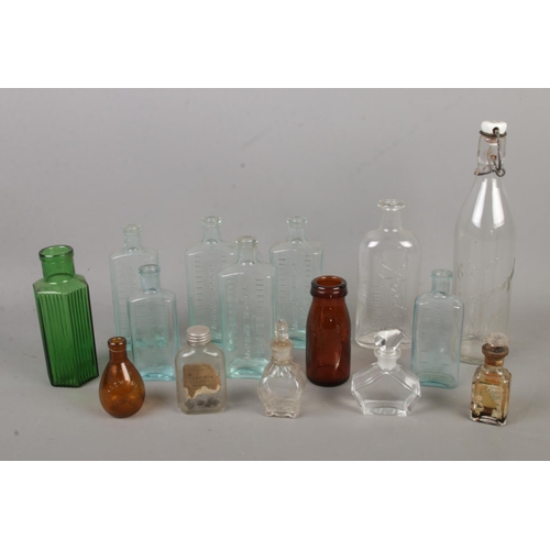 302 - A collection of assorted vintage glass bottles to include several chemists examples.