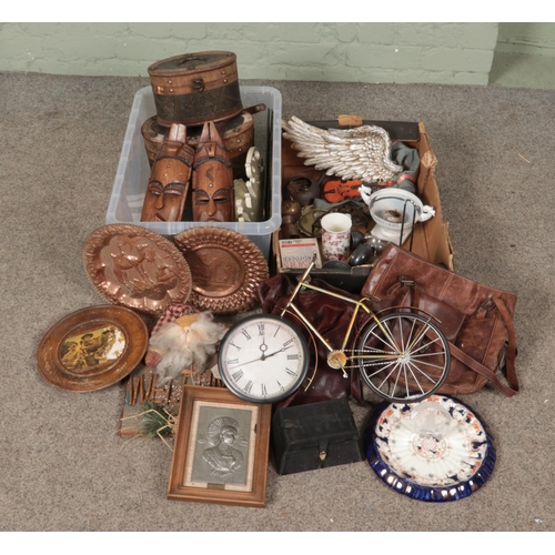 306 - Two boxes of miscellaneous. Includes tribal masks, bicycle clock, bags, storage boxes etc.