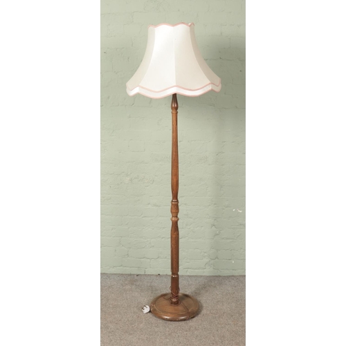 391 - A turned wooden standard lamp with shade.