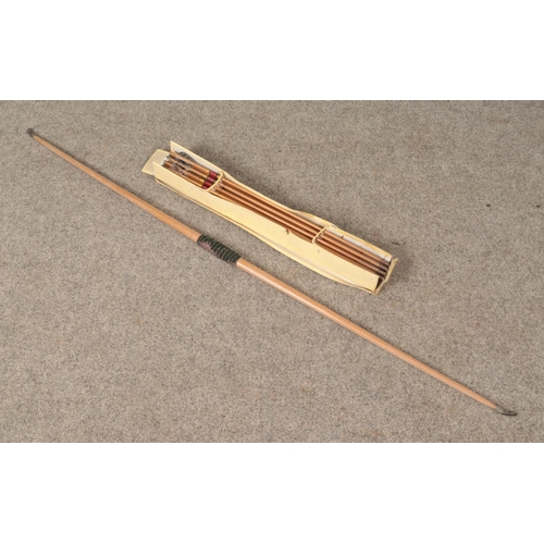 392 - A late 19th century to early 20th century yew wood bow along with a box of arrows both produced by F... 