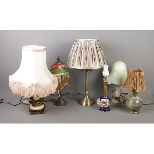 409 - A collection of small table lamps to include hardstone, and ceramic examples.