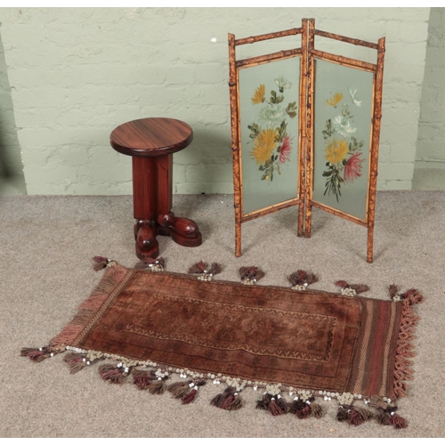 421 - A small vintage bamboo and glass screen with a wool rug and novelty plant stand.