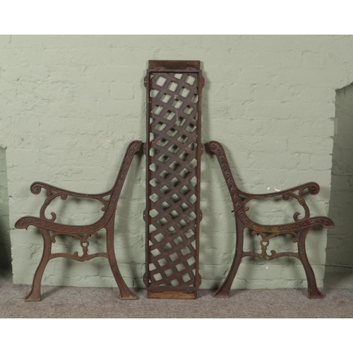 452 - A pair of wrought iron bench ends, along with a iron back panel.