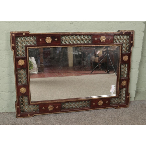 489 - A large ornate hardwood and gilt metal mirror. 85cm x 123cm.