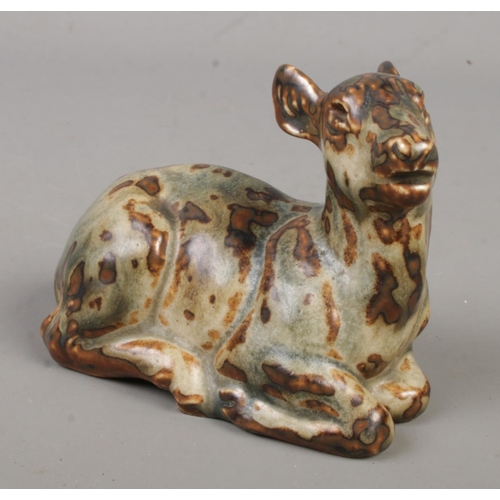 572 - An early Royal Copenhagen stoneware figure formed as a recumbent deer. Possibly by Knud Kyhn. Having... 