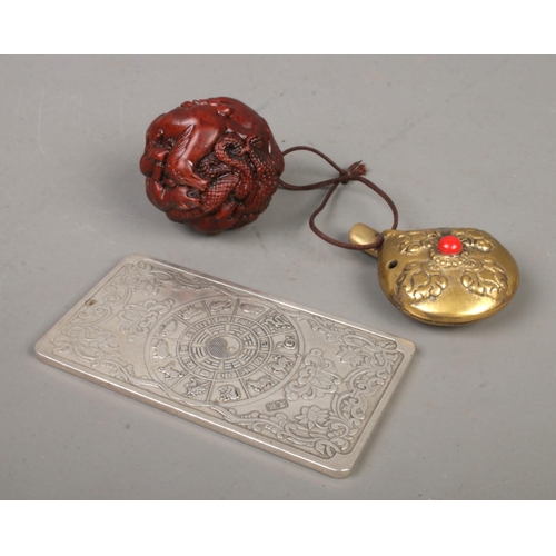 575 - A small collection of Oriental items. Includes Chinese white metal Zodiac ingot, spherical netsuke d... 