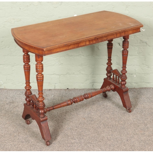 591 - A Victorian mahogany centre table raised on turned tapering column supports and castors on shaped fe... 