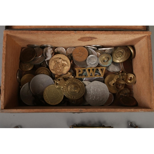 218 - A small box containing mainly cap badges pins and lapels, together with a small collection of coins.... 