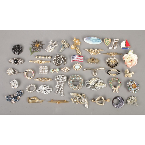 247 - A collection of over forty costume jewellery brooches, to include American flag, heart shaped, wreat... 