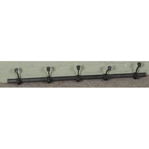 370 - A painted cast iron five hook wall mounting coat rack. (128cm)