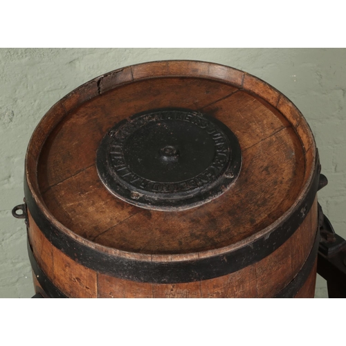 386 - An oak and metal bound barrel formed as a butter churn, raised on pine stand. The barrel stamped and... 