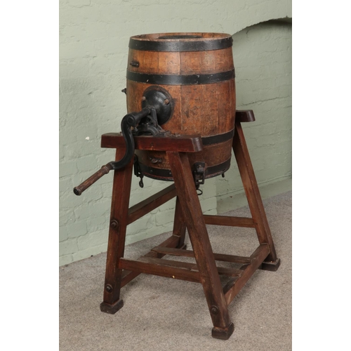 386 - An oak and metal bound barrel formed as a butter churn, raised on pine stand. The barrel stamped and... 