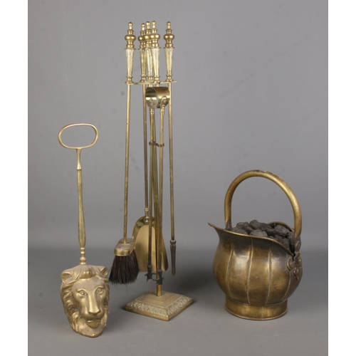 388 - A collection of brasswares, to include fire companion set, coal bucket and lion face door stop with ... 