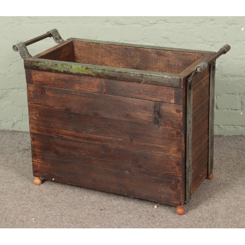 390 - A panelled log basket with metal surround, raised on small turned feet. Height: 64cm, Width: 84cm, D... 