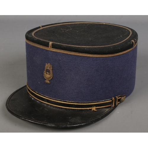 71 - A military kepi baring stitched lyre insignia.