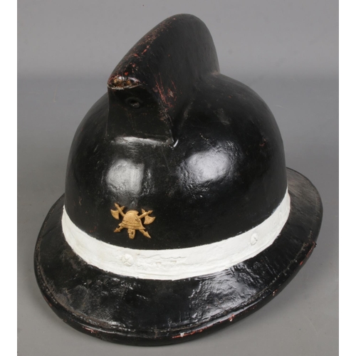 81 - A painted leather fireman's helmet baring axe & helmet insignia.