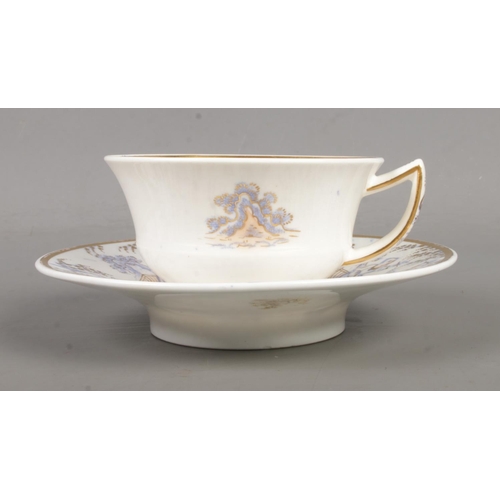 569 - A Rockingham teacup and saucer with 'figure 7' handle. Printed, enamelled and with gilded decoration... 