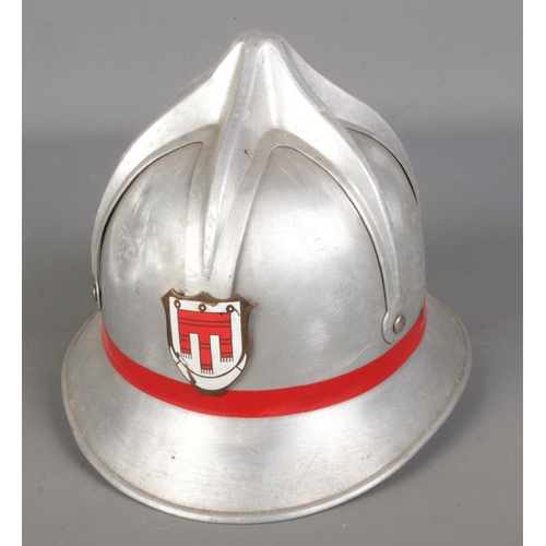 92 - A metal fireman's helmet with enamel crest.