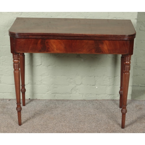 603 - A Victorian mahogany fold over table raised on tapering supports.