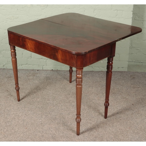 603 - A Victorian mahogany fold over table raised on tapering supports.