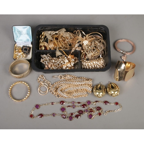 245 - A collection of assorted gold tone jewellery, to include large statement earrings, hinged bangles, p... 