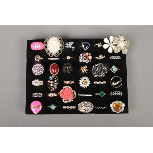 249 - Thirty six costume jewellery dress rings, to include frog, crossover, floral and cameo examples.