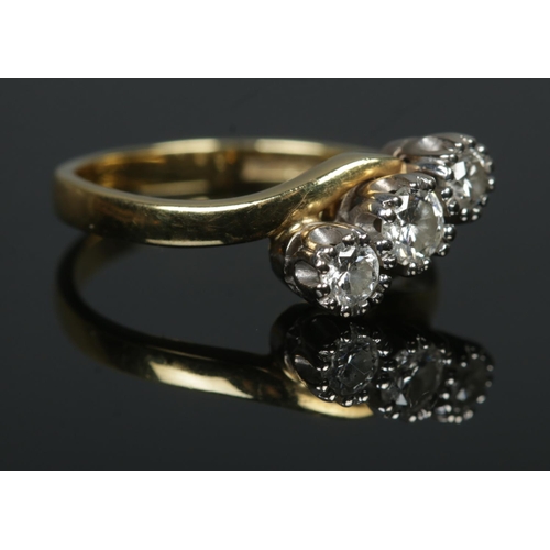 534 - An 18ct Gold and three stone diamond crossover ring; the largest stone ¼ct. Size K½. Total weight: 3... 