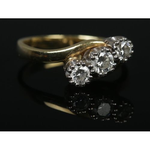 534 - An 18ct Gold and three stone diamond crossover ring; the largest stone ¼ct. Size K½. Total weight: 3... 