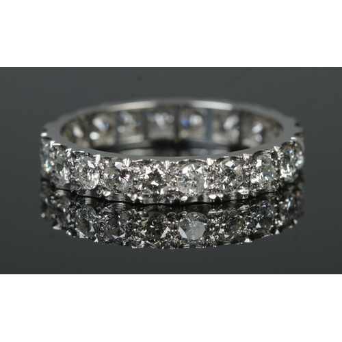 A platinum and diamond eternity ring, containing twenty-one stones, all sized approximately 1/16ct. Stamped 'PLAT' to the side. Size L½. Total weight: 3g.