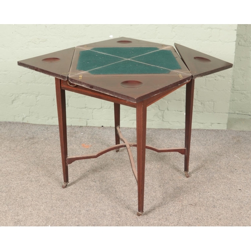 588 - An Edwardian mahogany envelope card table, with drawer to the front, baize interior and banded decor... 