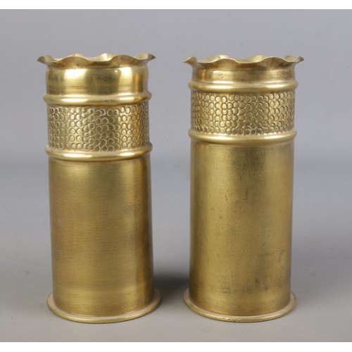 69 - Trench Art; A pair of early Twentieth Century and WWI artillery shell vases with hammered band and f... 