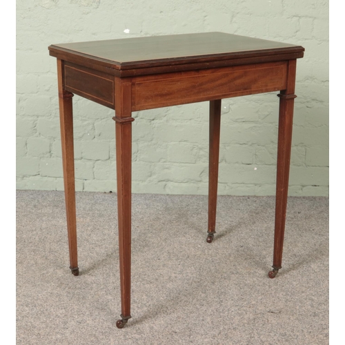 563 - An Edwardian mahogany fold over games table.