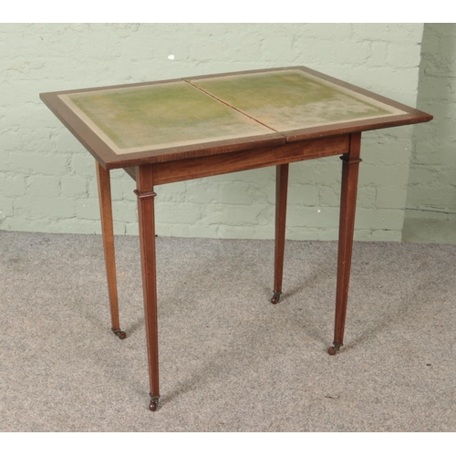 563 - An Edwardian mahogany fold over games table.