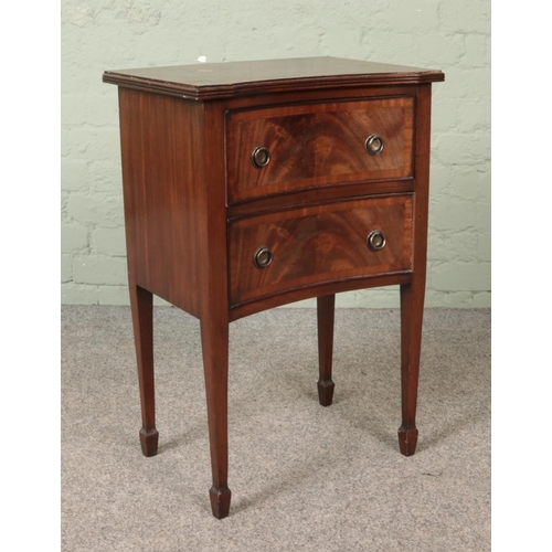 567 - A small two drawer mahogany chest raised on tapering supports.