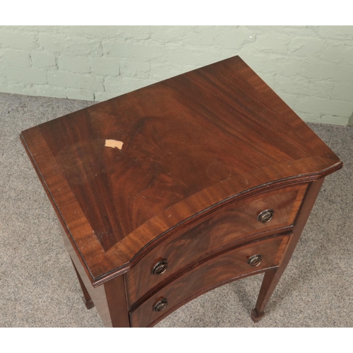 567 - A small two drawer mahogany chest raised on tapering supports.