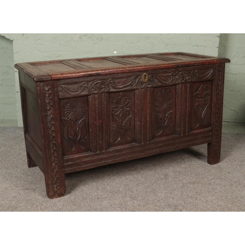 571 - An 18th century carved and pannelled oak coffer.