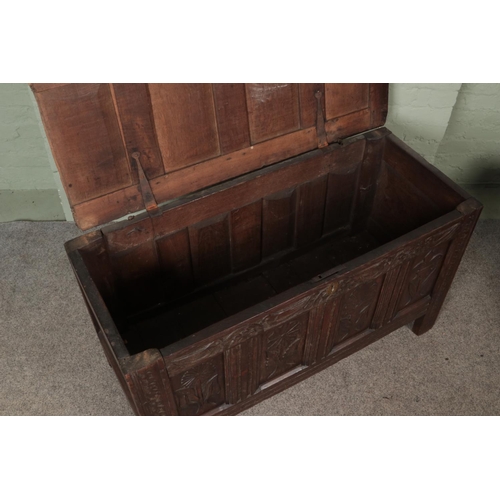 571 - An 18th century carved and pannelled oak coffer.