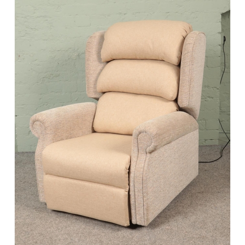 572 - A 2023 model Repose electric riser/recliner armchair, with remote, in cream upholstered fabric. Comp... 