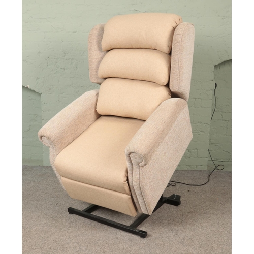 572 - A 2023 model Repose electric riser/recliner armchair, with remote, in cream upholstered fabric. Comp... 