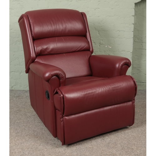 574 - A red leather reclining armchair.