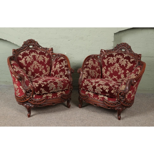 578 - A pair of carved mahogany tub arm chairs with red floral upholstery.