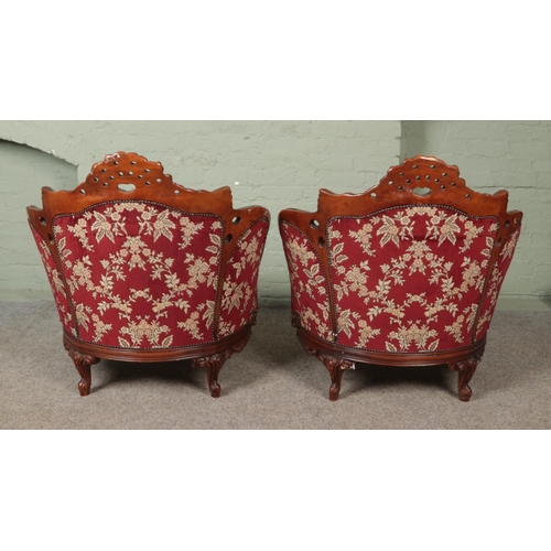 578 - A pair of carved mahogany tub arm chairs with red floral upholstery.