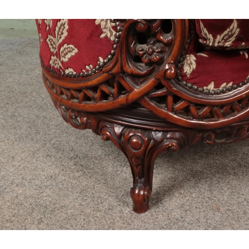 578 - A pair of carved mahogany tub arm chairs with red floral upholstery.