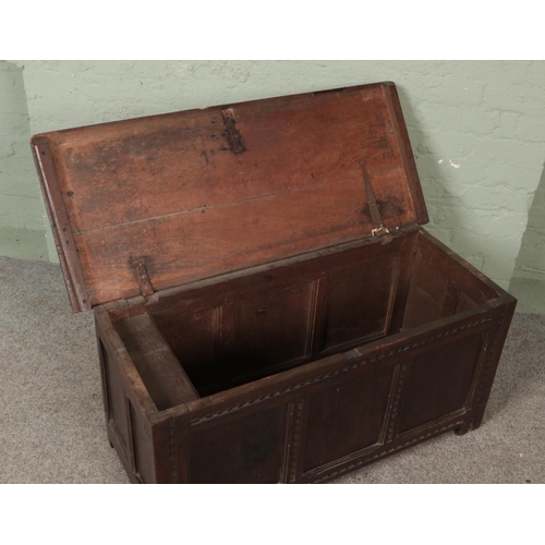 580 - A Georgian carved and panelled oak blanket box with candle box to interior.